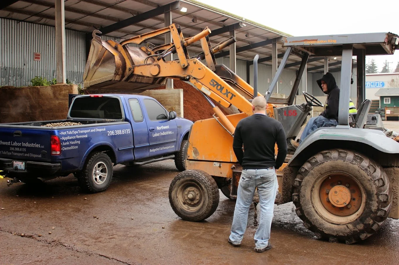 a man in black beside a demolition truck